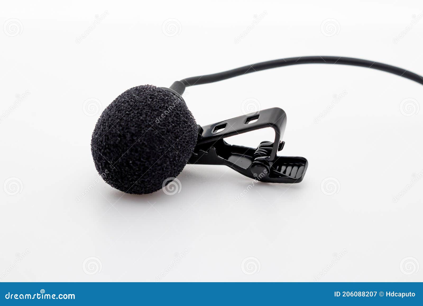 lavalier or lapel microphone on a white surface, very close-up. the details of the grip clip or bra and the sponge against the