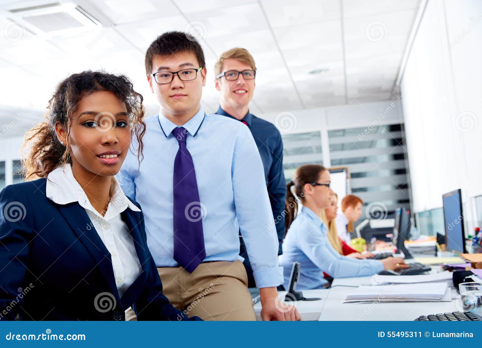 Lavoro di squadra etnico dei giovani del gruppo di affari multi in computer di ufficio