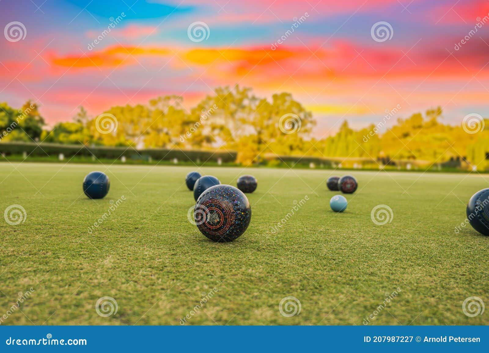 lawn bowls balls in a field after the game with a colourful sunset