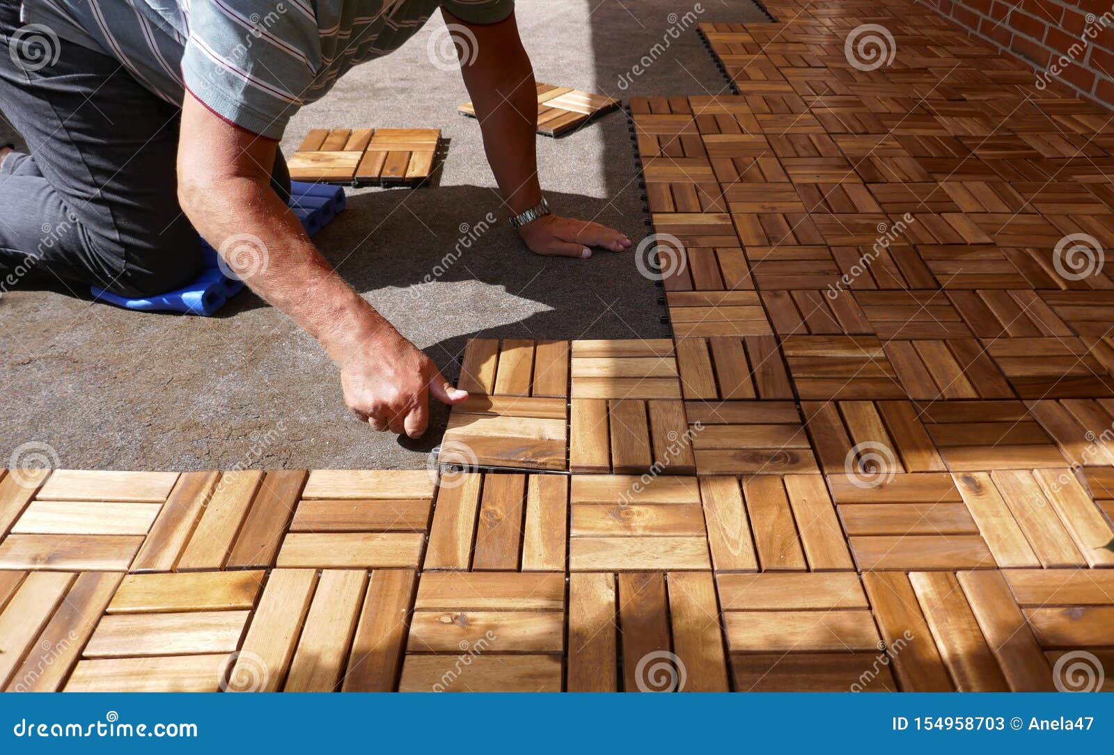 Lay Wooden Tiles On A Terrace. Square Wood Panels Are Connected With Lock Clic Stock Image