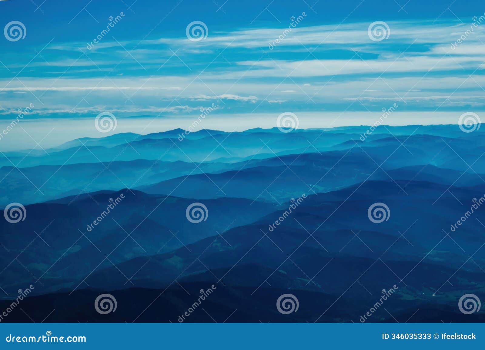 layered blue mountain ranges under serene sky