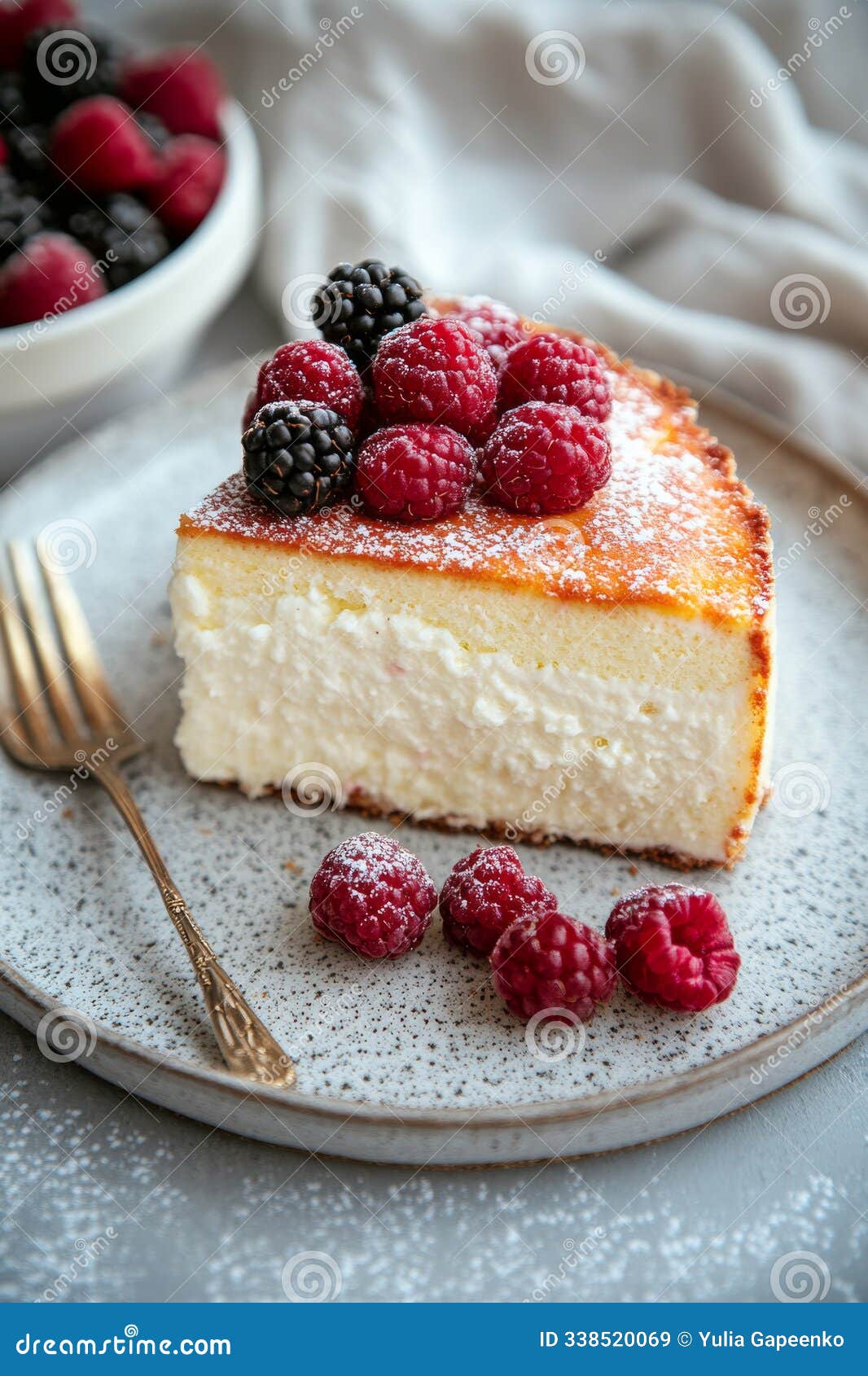 layered cake topped with fresh berries and flowers on a rustic plate