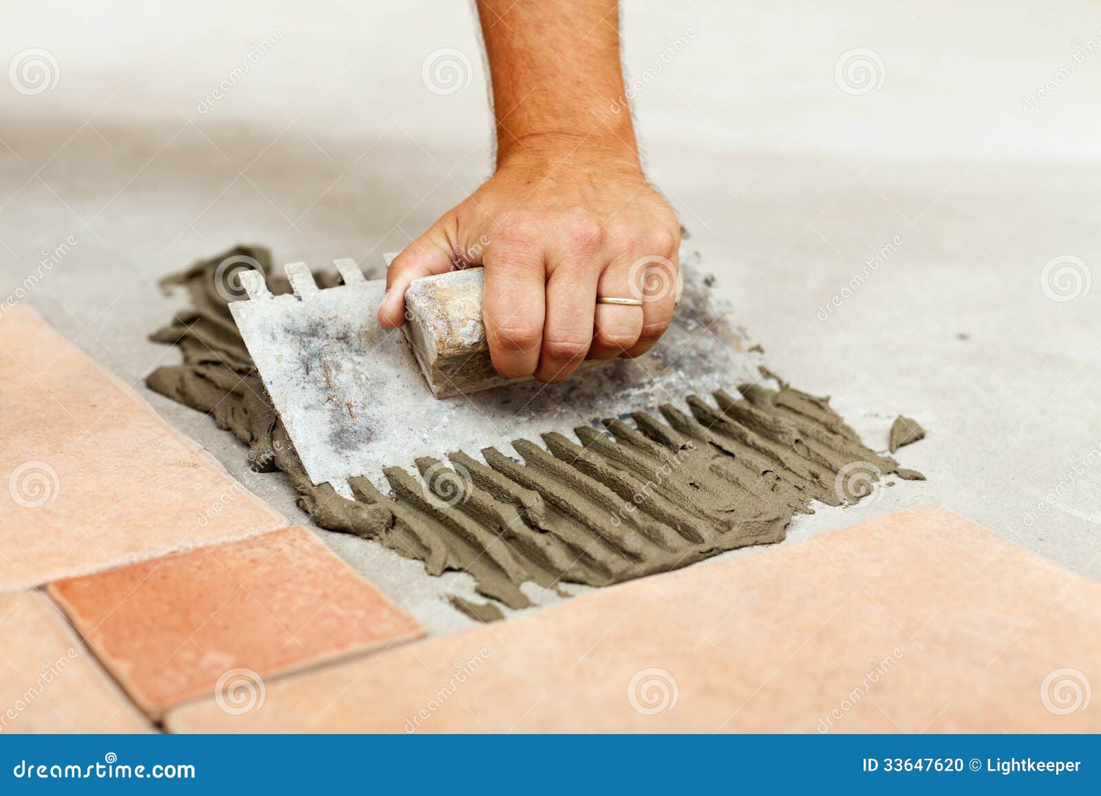 Laying ceramic floor tiles stock photo. Image of glue 33647620