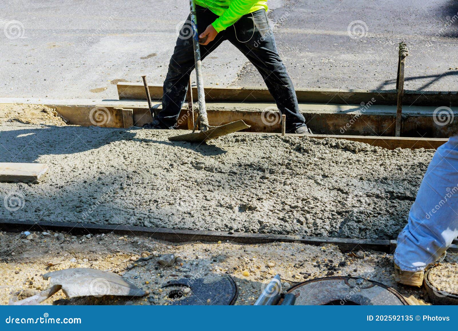 laying down a new sidewalk in wet concrete on freshly poured sidewalks