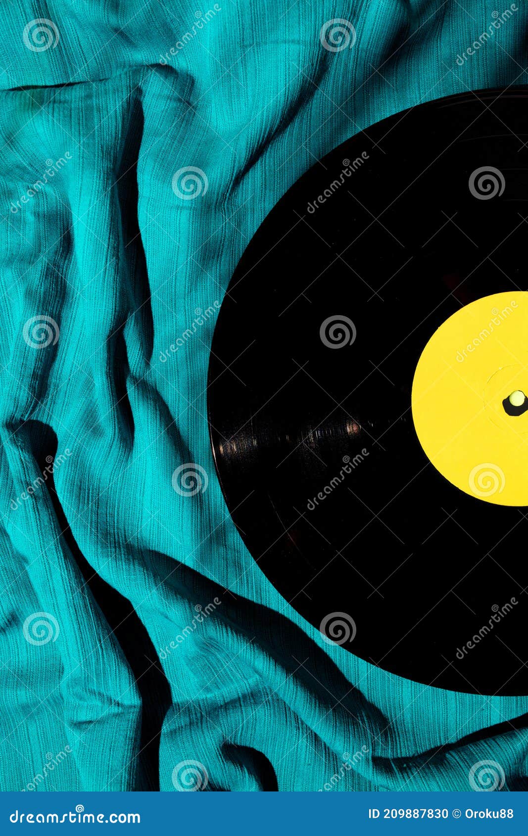 layout of lp vinyl record on a cyan silk or saten fabric. old vintage record