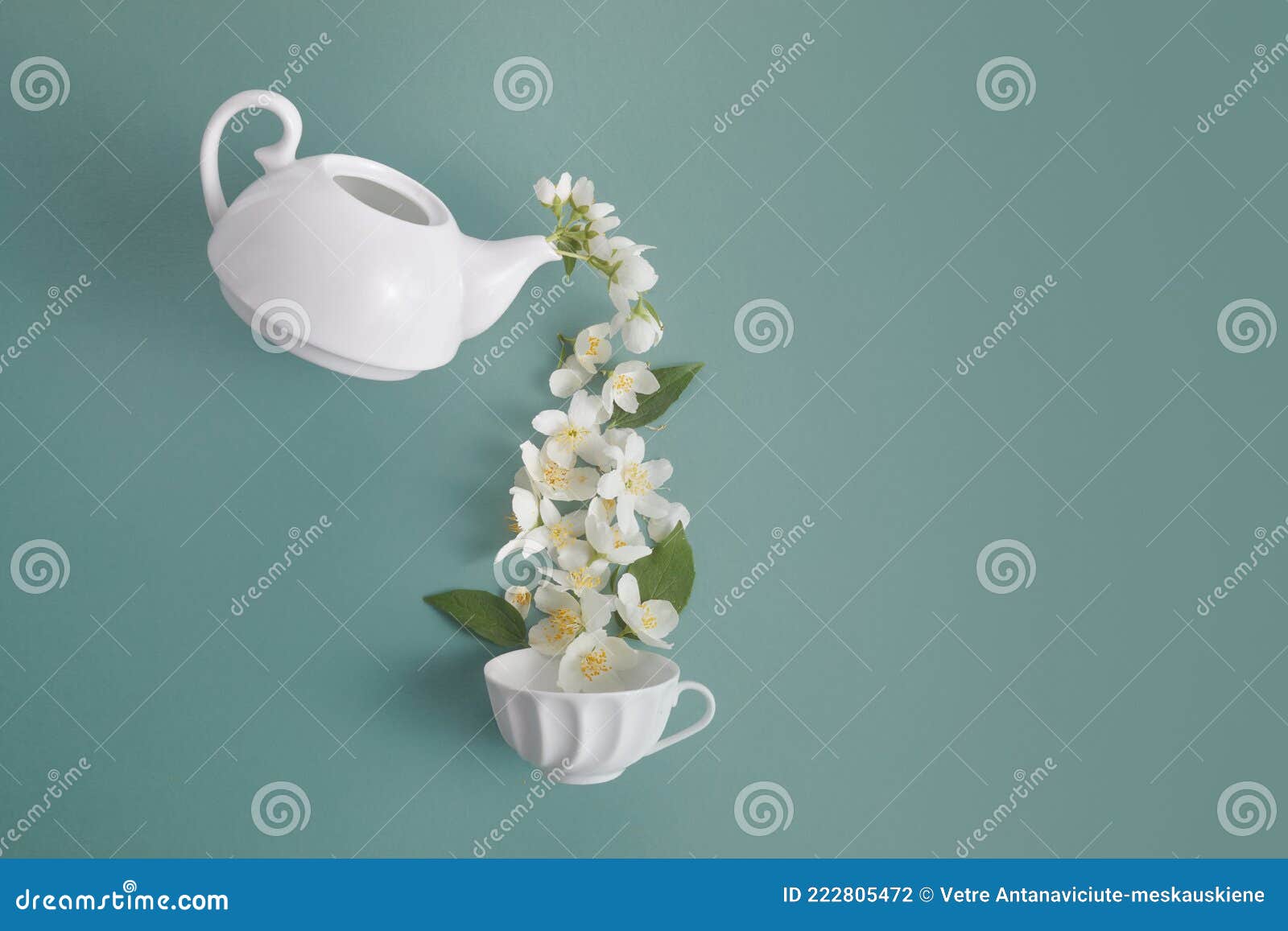 Layout of Teapot and Tea Cup with Jasmine Flowers on a Green Background
