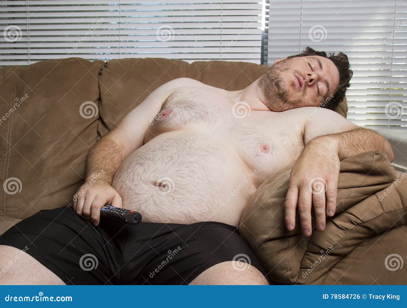 Lazy fat guy watching TV stock photo