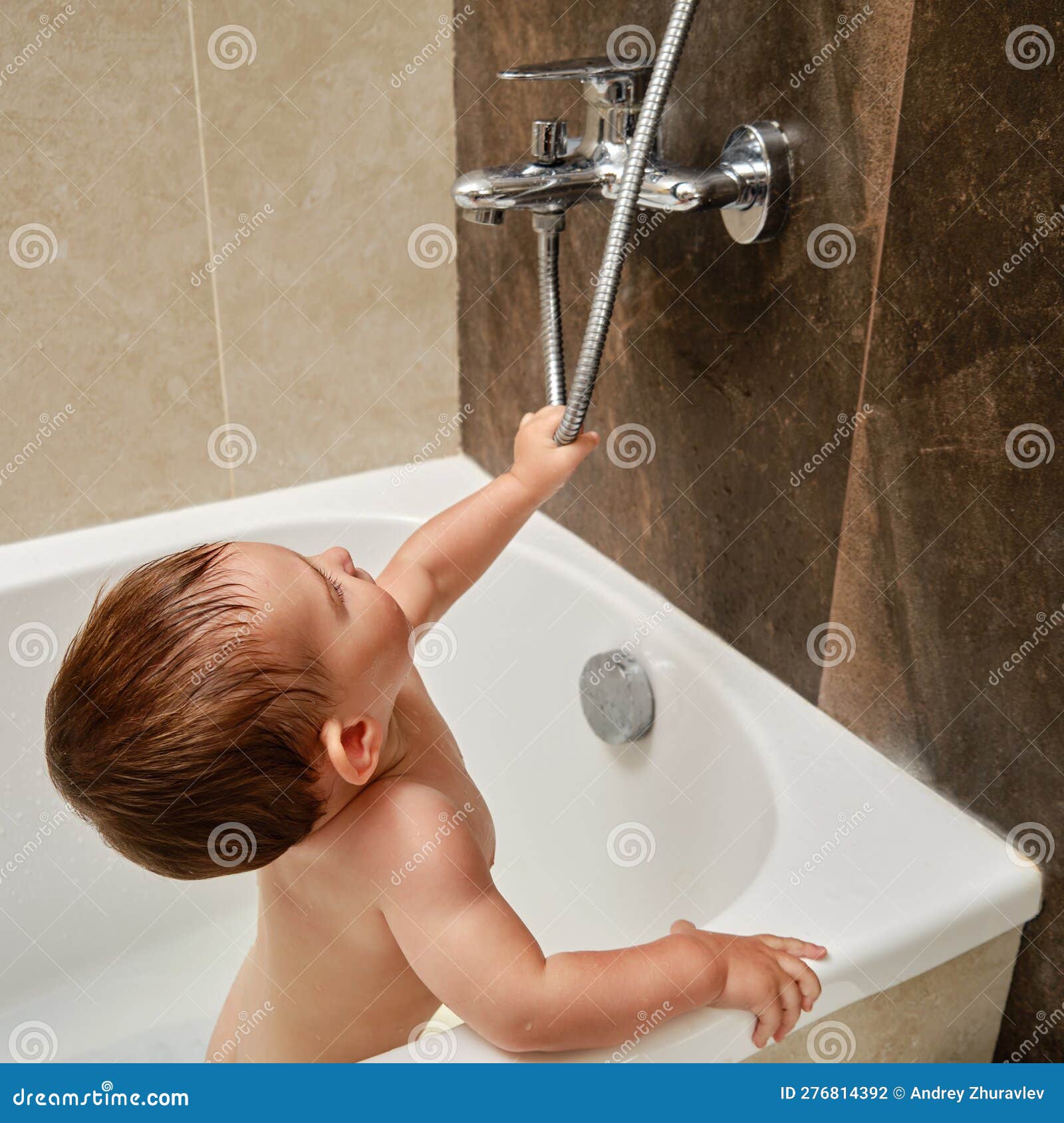 Le Bébé Garçon En Bas âge Joue Avec Un Robinet Et Une Douche En Se Tenant  Debout Photo stock - Image du visage, inondation: 276814392