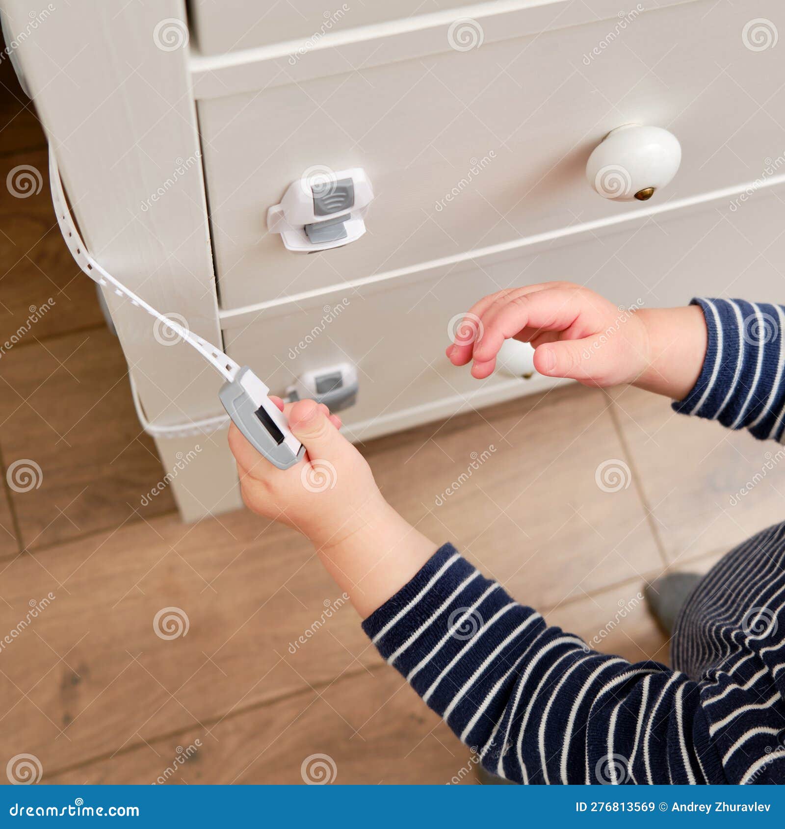 Le Bébé Ouvre La Serrure De L'enfant Sur Le Tiroir Fermé De L'armoire.  Bambou Image stock - Image du chéri, ouvert: 276813569