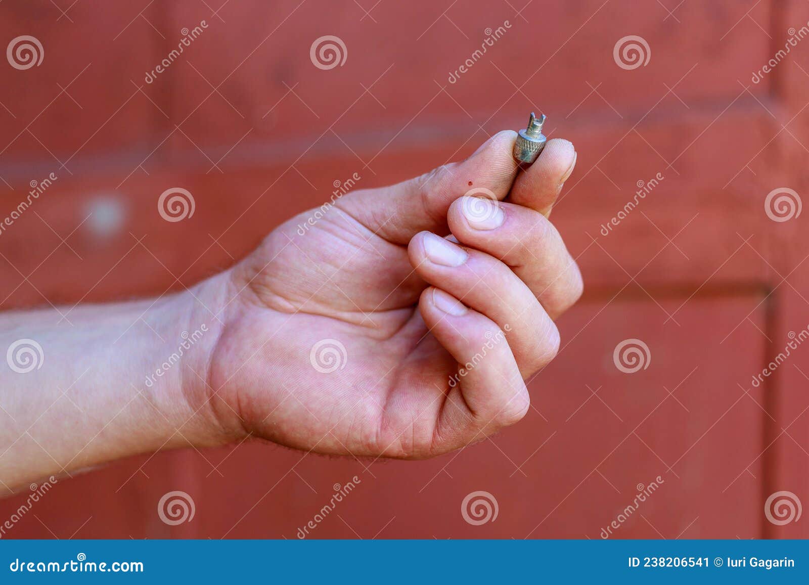 Le Dita Della Mano Tengono Il Capezzolo Dalla Ruota Dell'auto