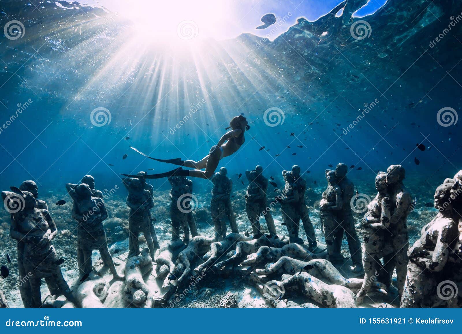 Le freediver de femme avec des ailerons plongent près des statues sous-marines Tourisme sous-marin dans l'océan