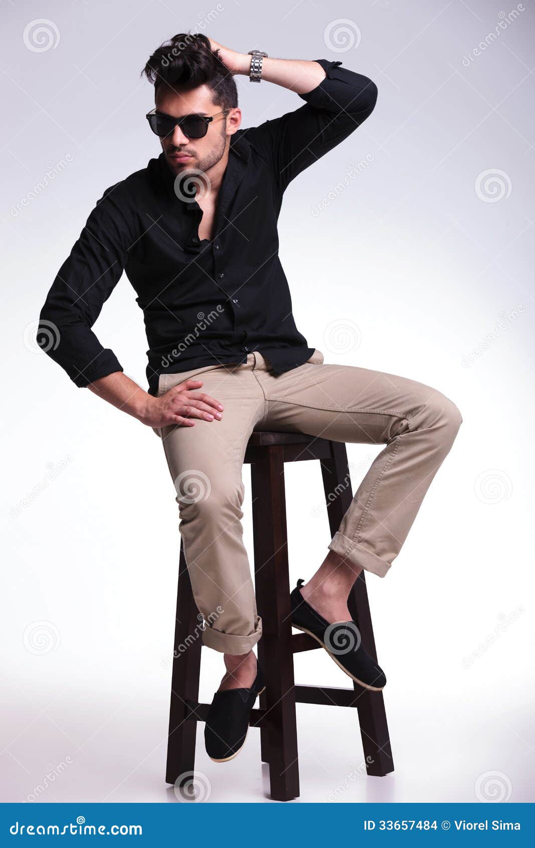 Le Jeune Homme Assis Fixe Ses Cheveux Photo stock Image du main