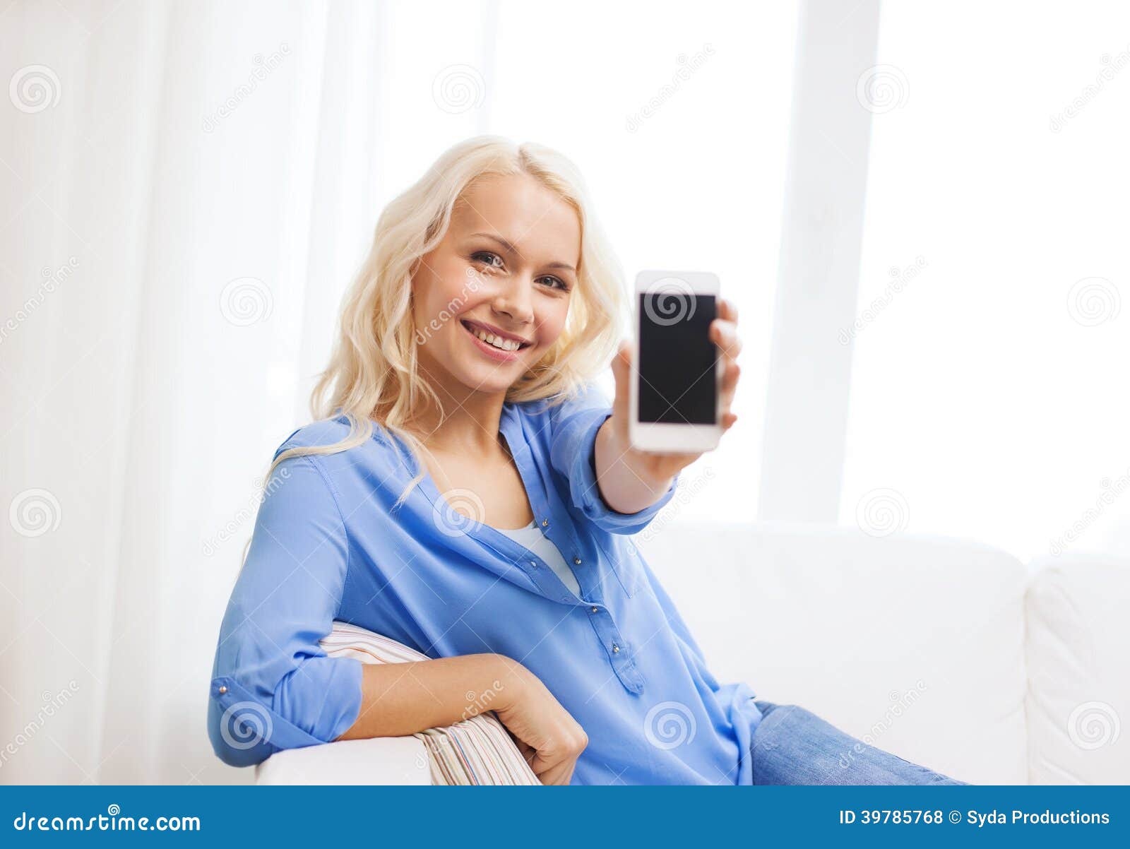 Le kvinnan med den tomma smartphoneskärmen hemma. Hem-, teknologi-, advertizing- och internetbegrepp - le kvinnan med den tomma smartphonen avskärma sammanträde på soffan hemma