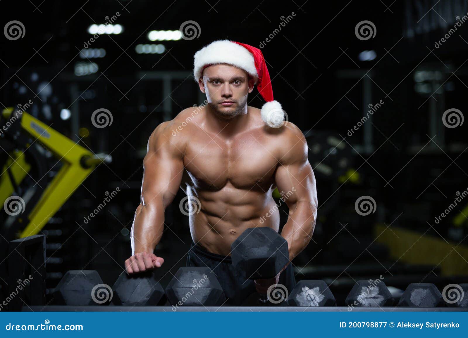 Le Père Noël Musculaire Bodybuilder Fait Des Exercices Avec Des Haltères Dans Une Vue De Face De 