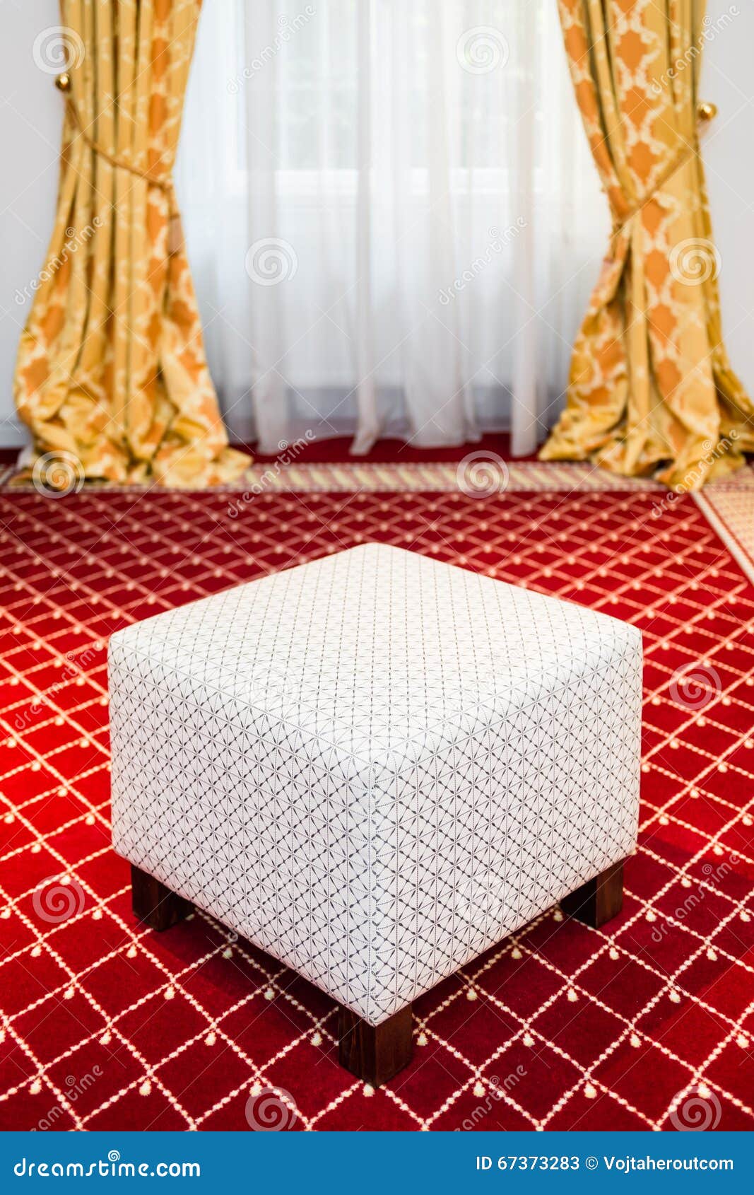 Le pouf blanc dans la chambre avec le tapis rouge et le jaune de ...