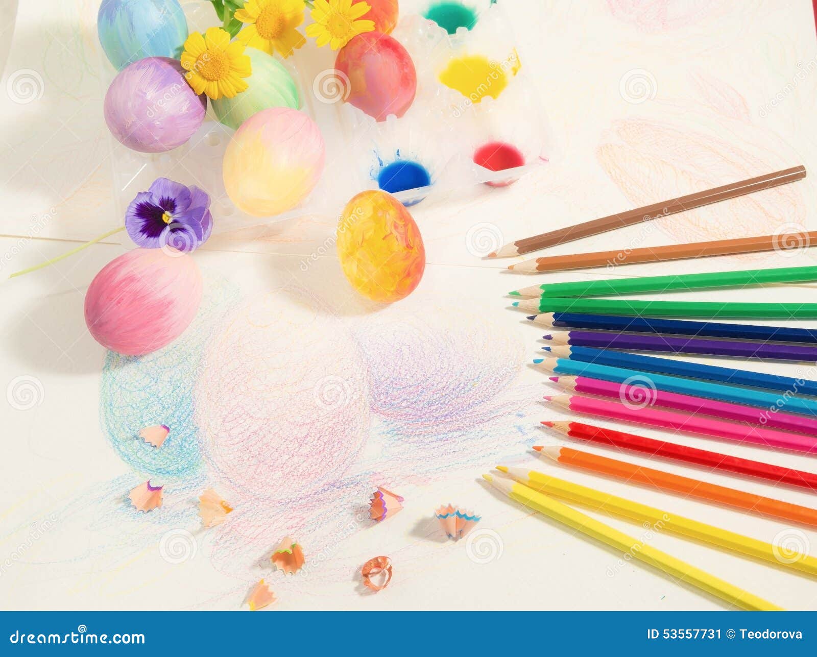 Le uova dipinte a mano di Pasqua con le matite colorate acquerelli e fiori della molla hanno sistemato sul disegno colorato Hobby pittura