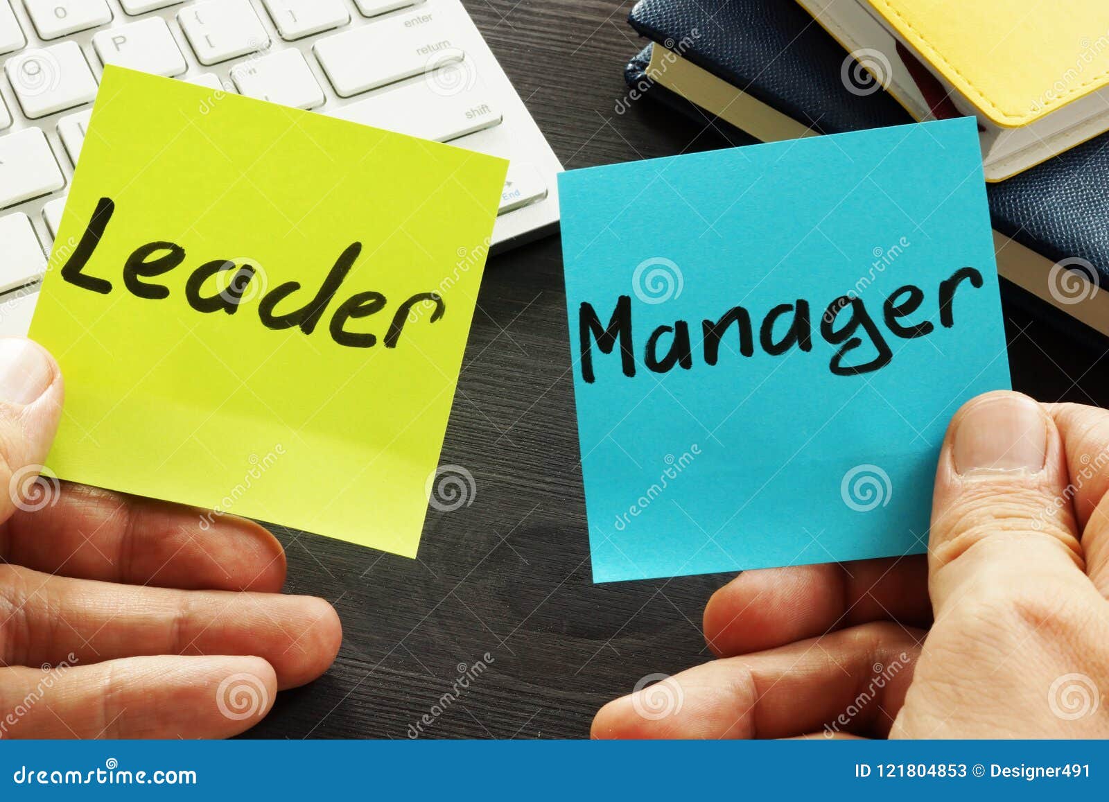 leader vs manager. man holding memo sticks.