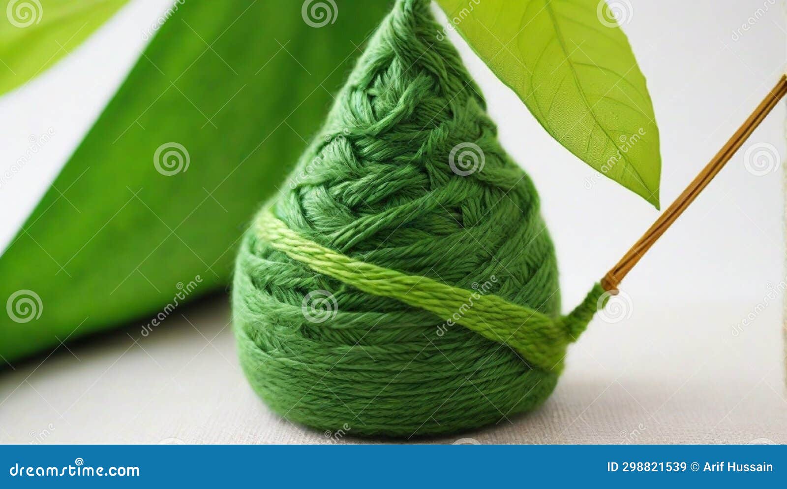 Leaf on a Green Yarn Cone with a Backdrop of a Green Fabric, Stock
