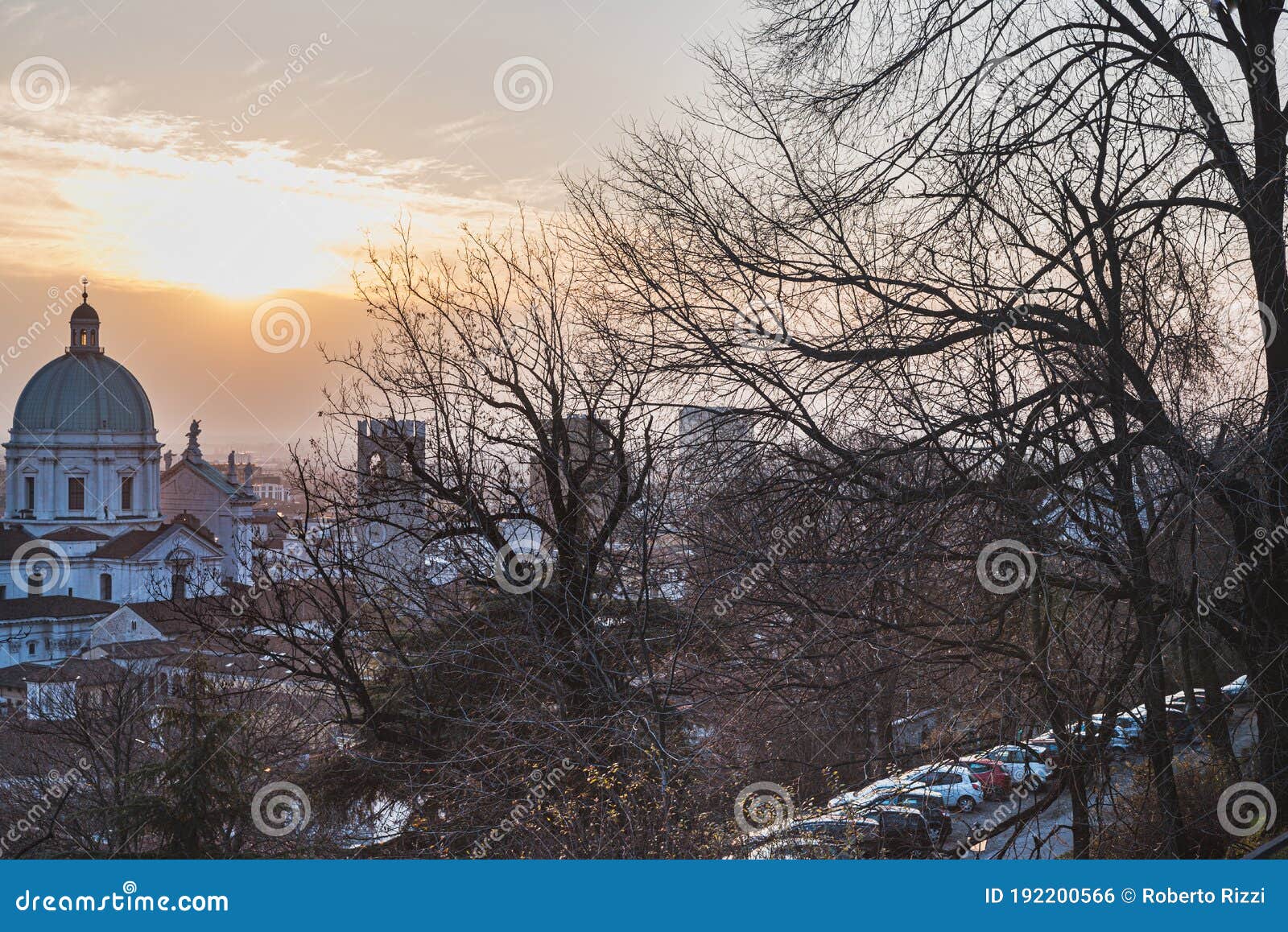 italian architecture and nature: woods on colle cidneo with the dome of santa maria assunta (saint mary cathedral)