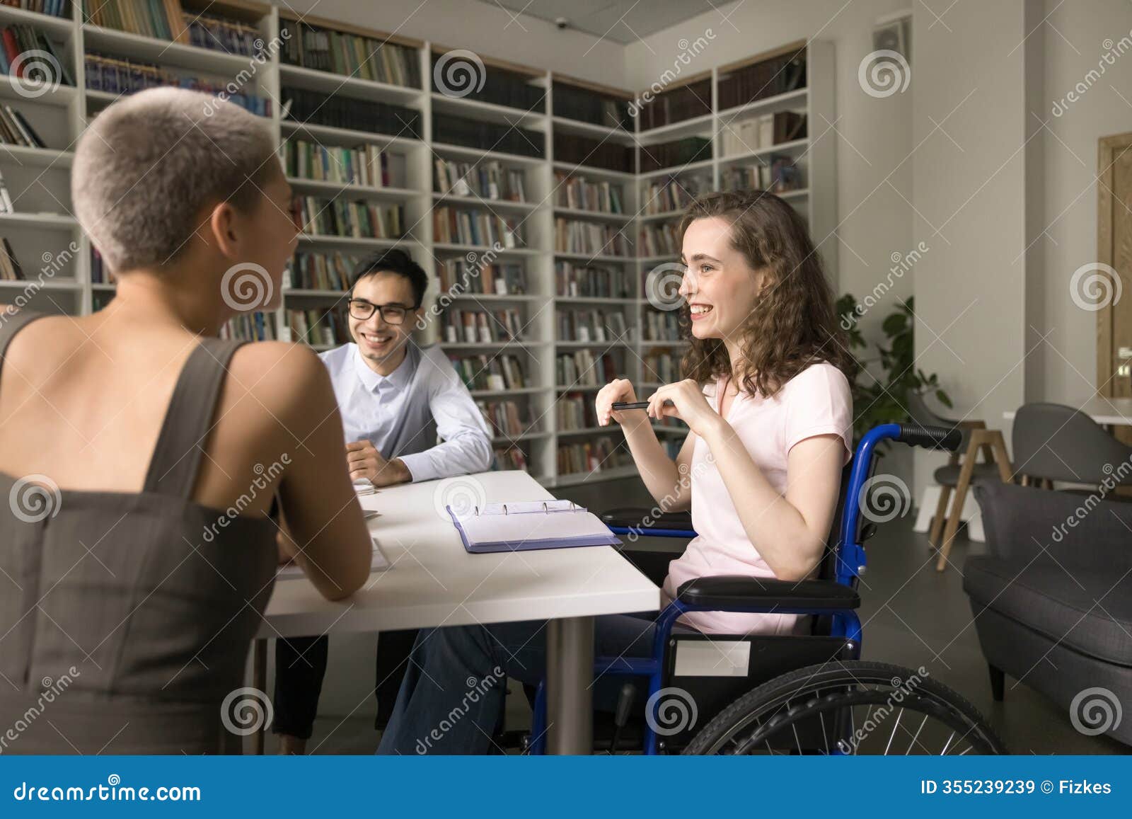teen girl student using wheelchair share funny idea with groupmates