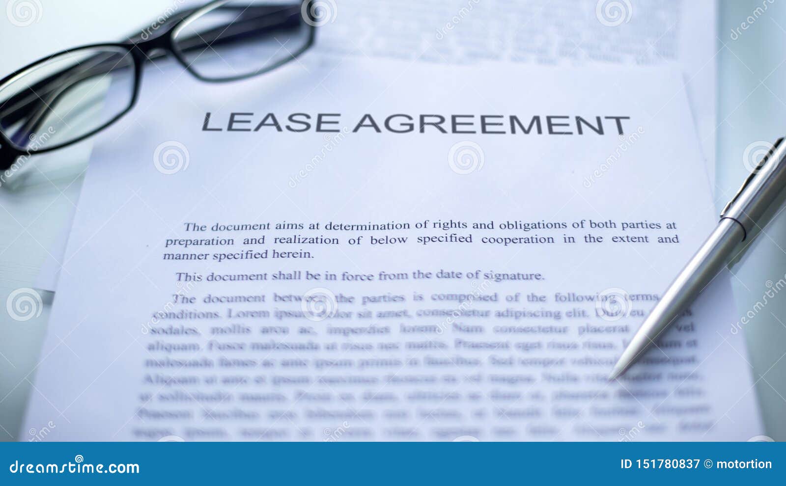 lease agreement lying on table, pen and eyeglasses on official business document