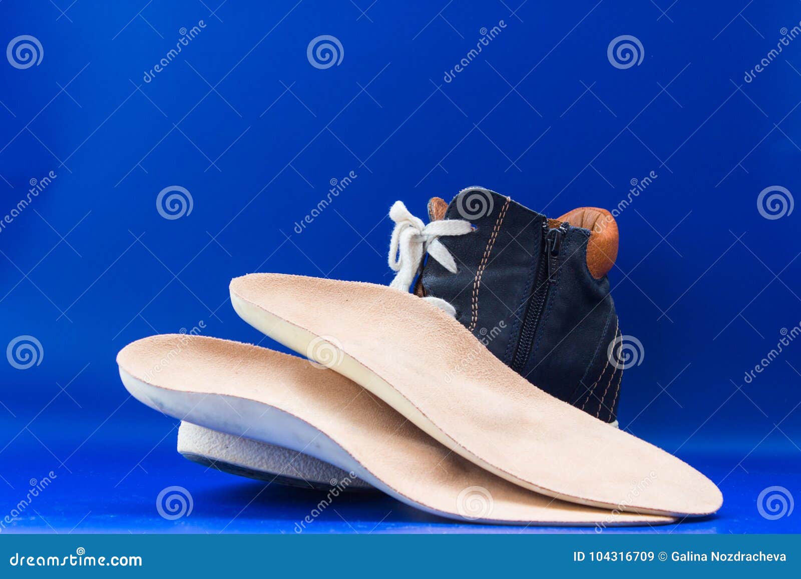 Leather Orthopedic Insoles with Boot. Blue Background Stock Image