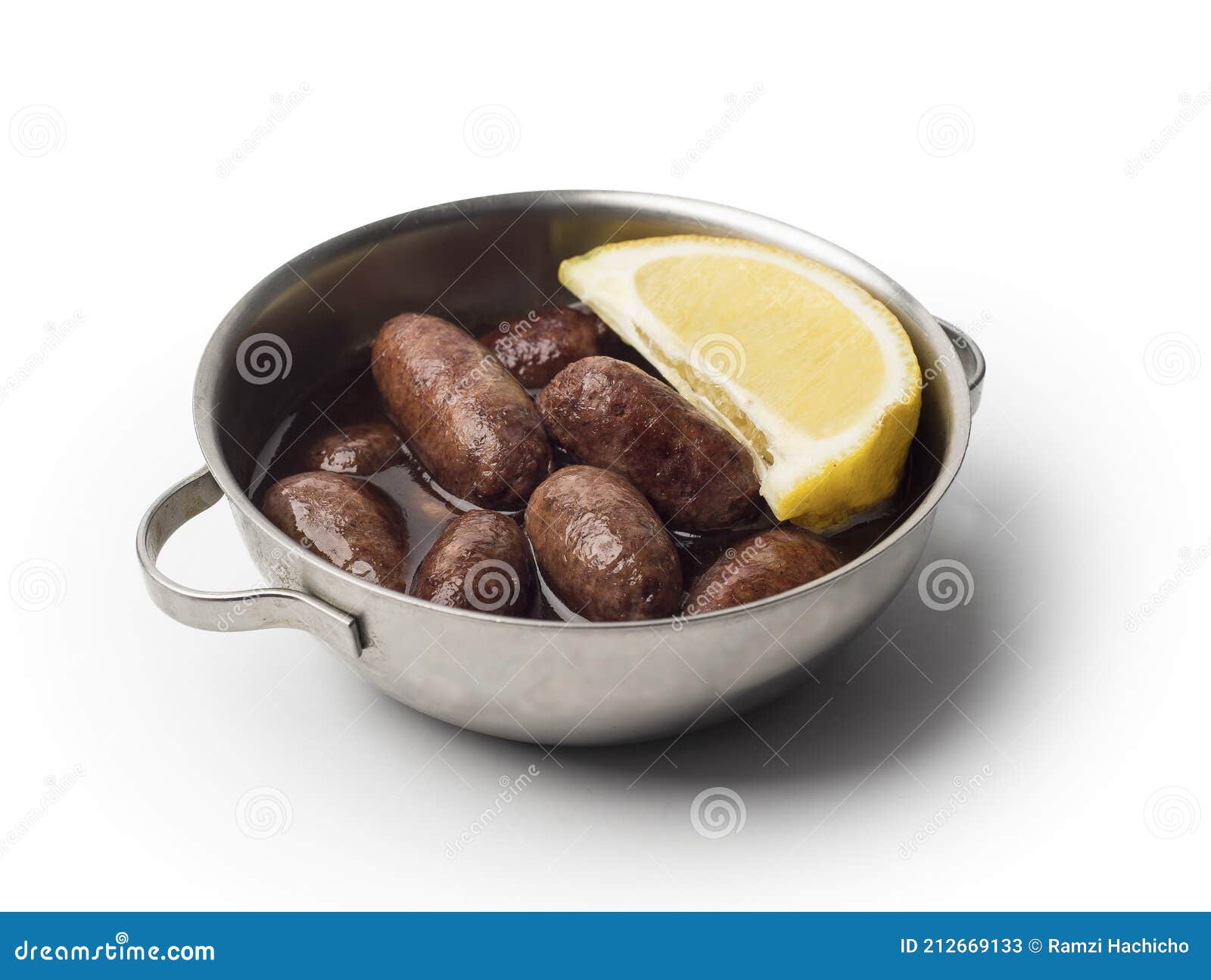 lebanese starters of makanek meat marinated, sausages fried in a metal pan