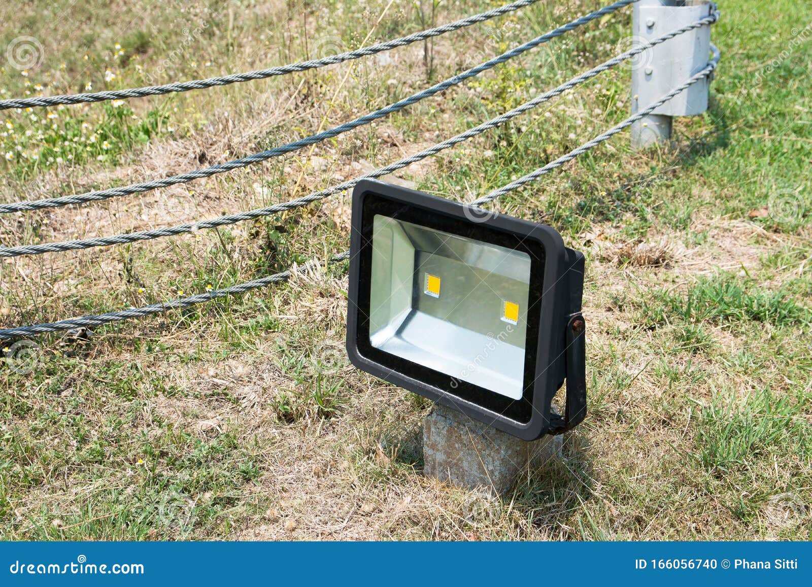 LED Flood Light on Ground Post with Metal String Fence Background Stock