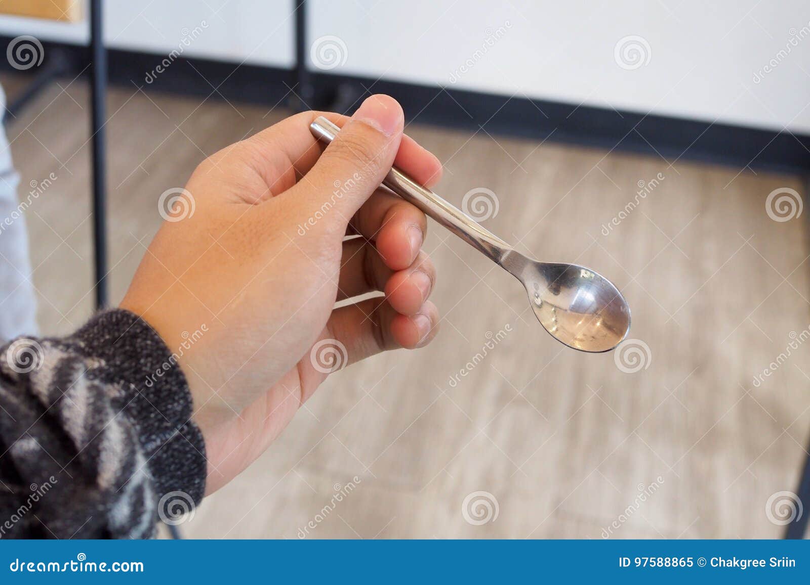 Left hand holding a spoon stock image. Image of wooden 97588865