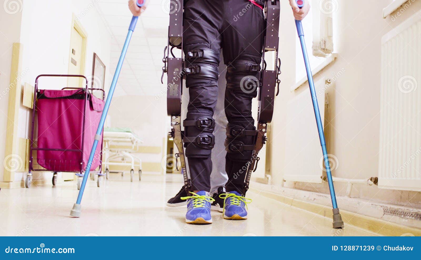 legs of invalid in robotic exoskeleton walking through the corridor