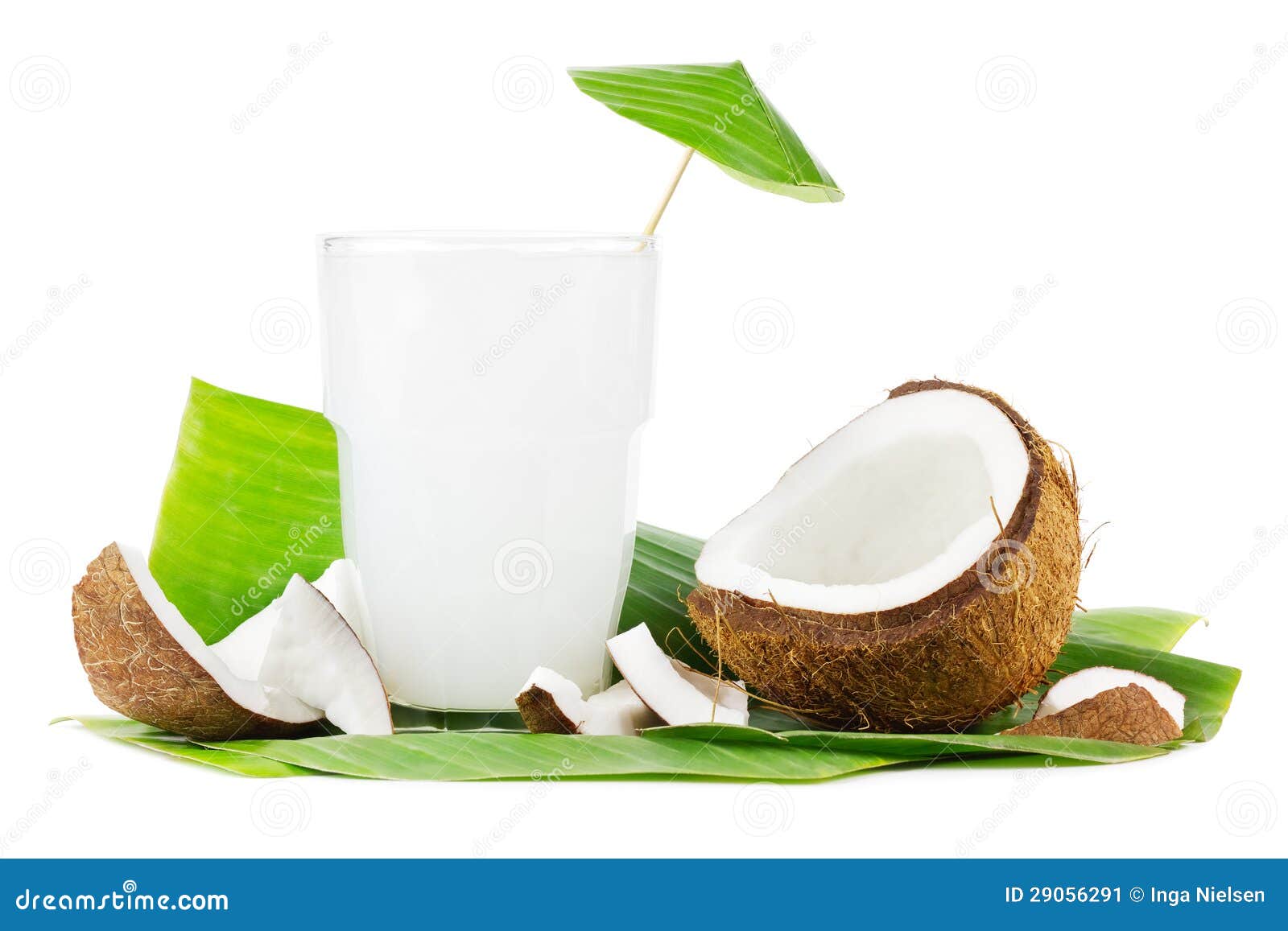 Leite de coco no branco. Vidro grande do leite de coco com cocos em um fundo branco.