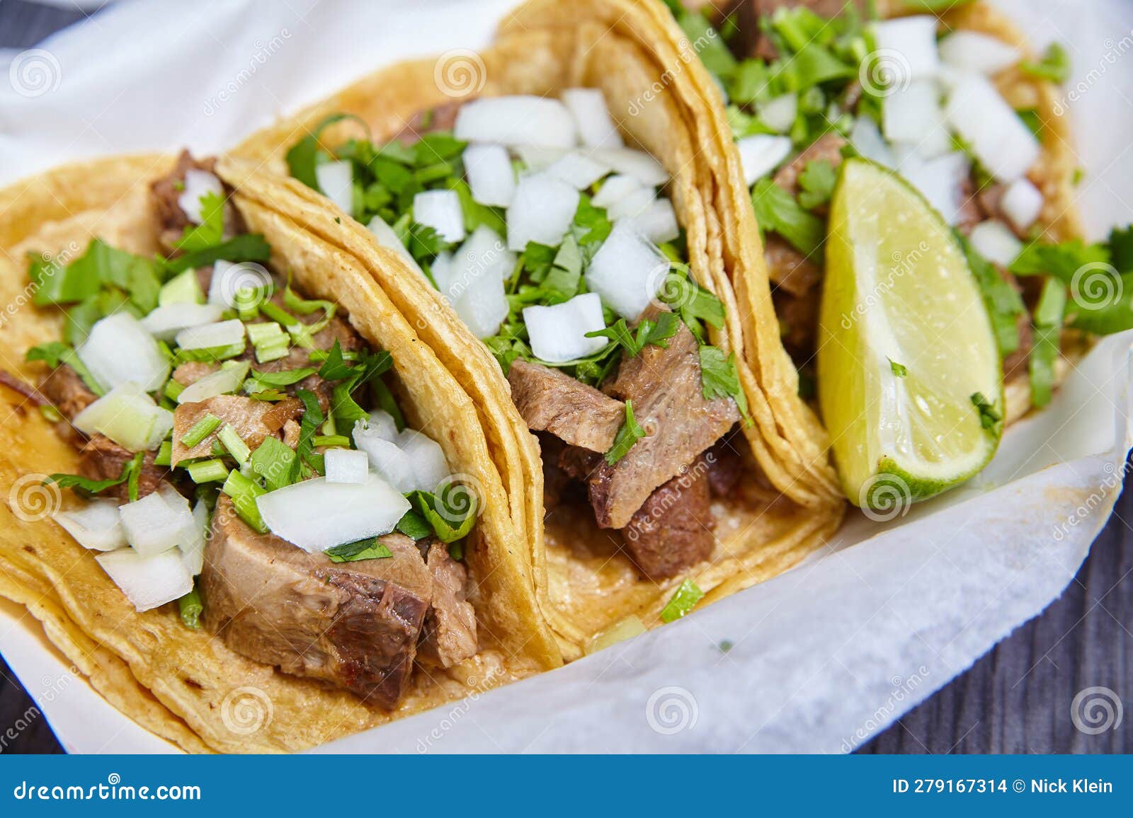 lengua chow beef tongue 3 street tacos mexican with cilantro, lime wedge, and onions