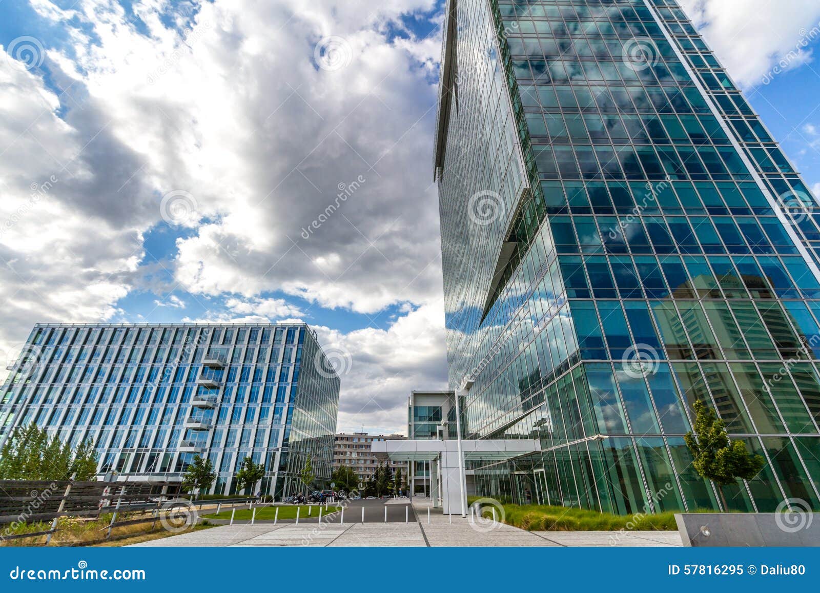 Les immeubles de bureaux réfléchissants en verre contre le ciel bleu avec les nuages et le soleil s'allument, République Tchèque