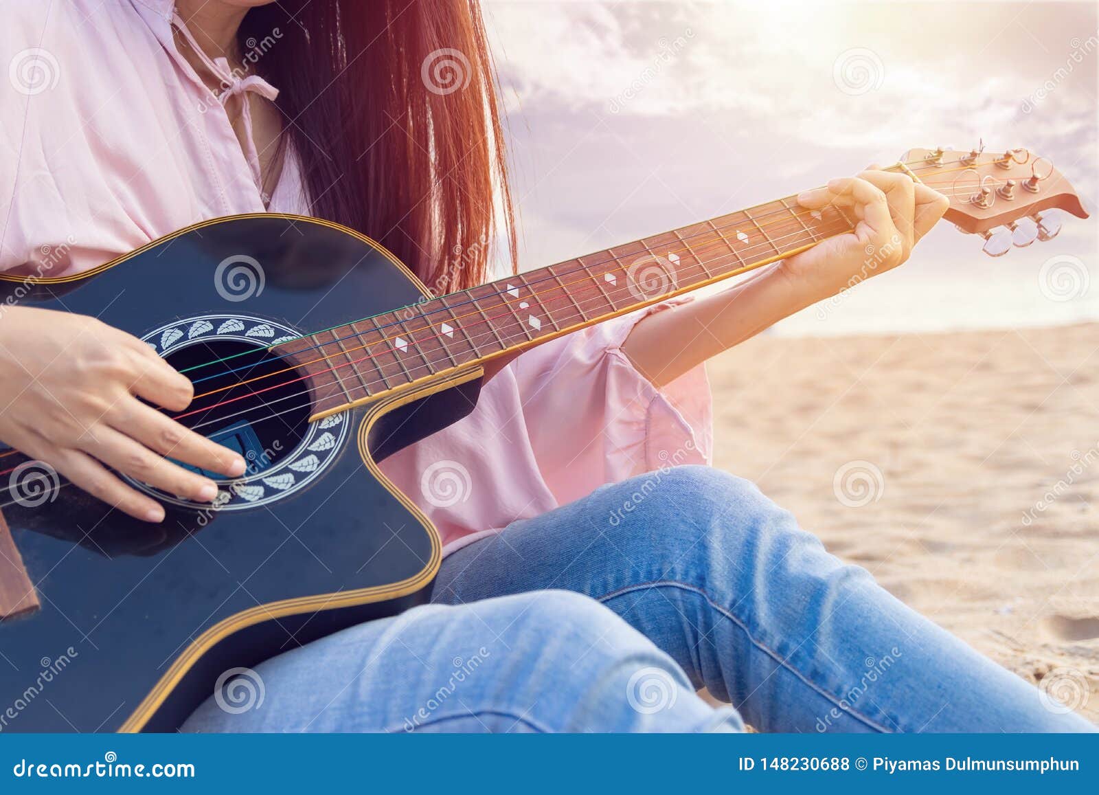 Les Mains De La Femme Jouant La Guitare Acoustique Cordes De Capture Par Le Doigt Sur La Plage