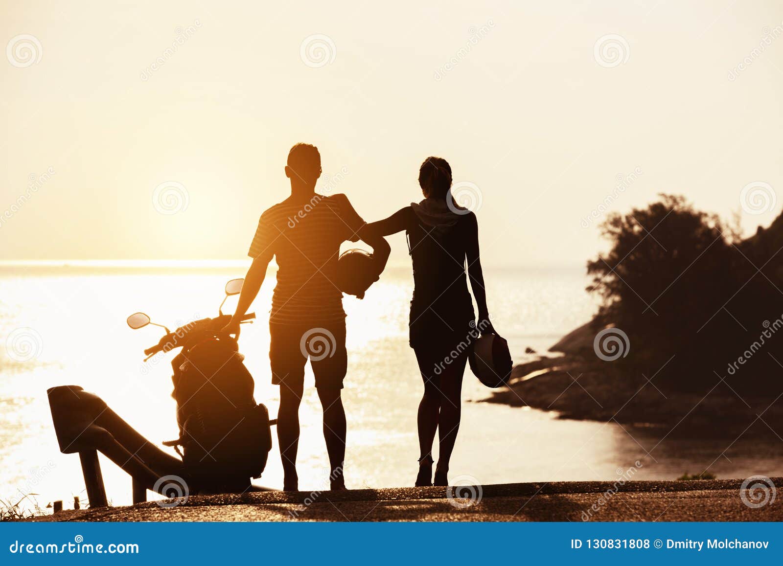 Les Silhouettes Du Couple Avec La Moto Contre La Mer De