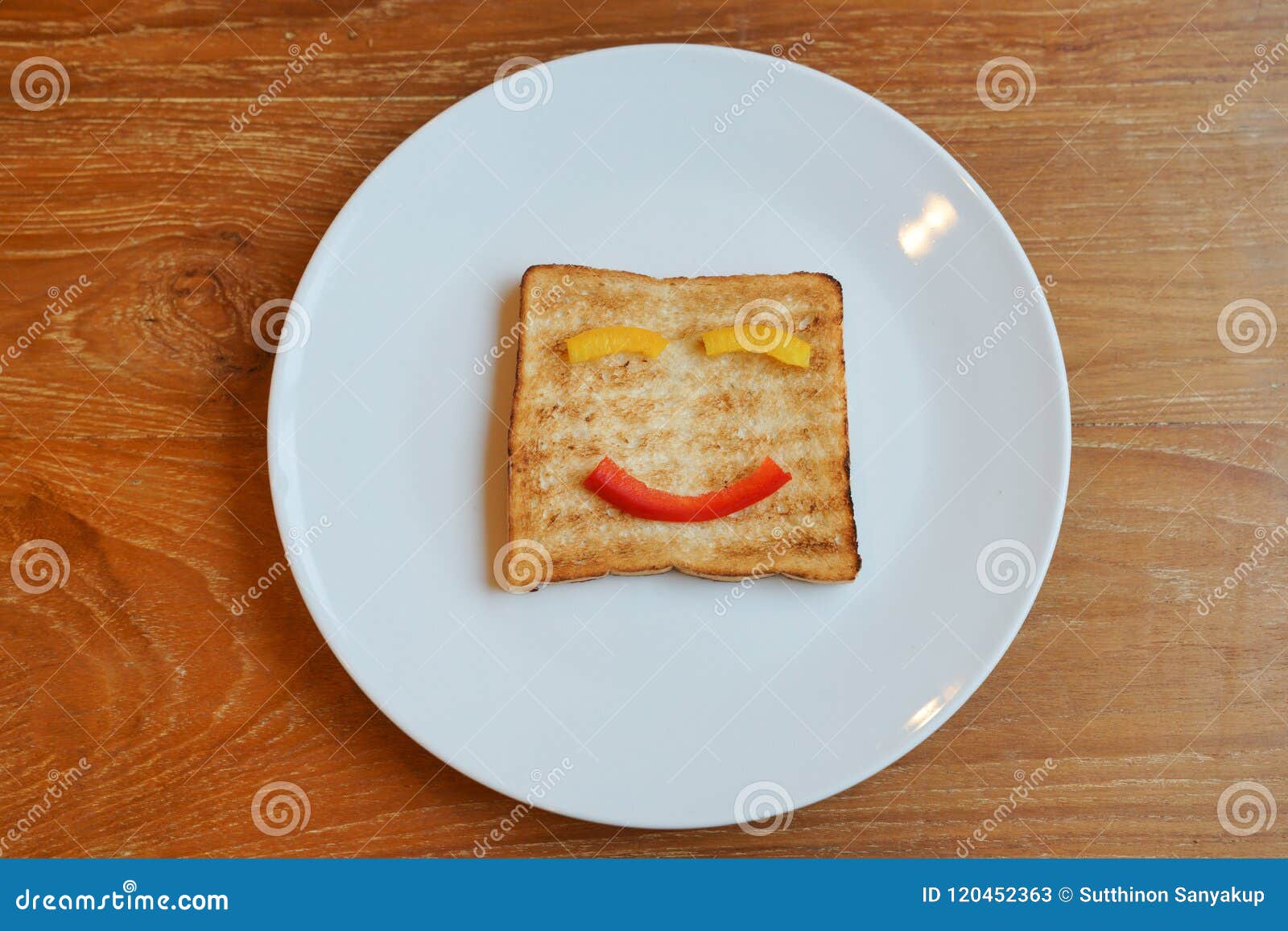 Les visages de sourire peints sur le pain de tranche, concept heureux de petit déjeuner