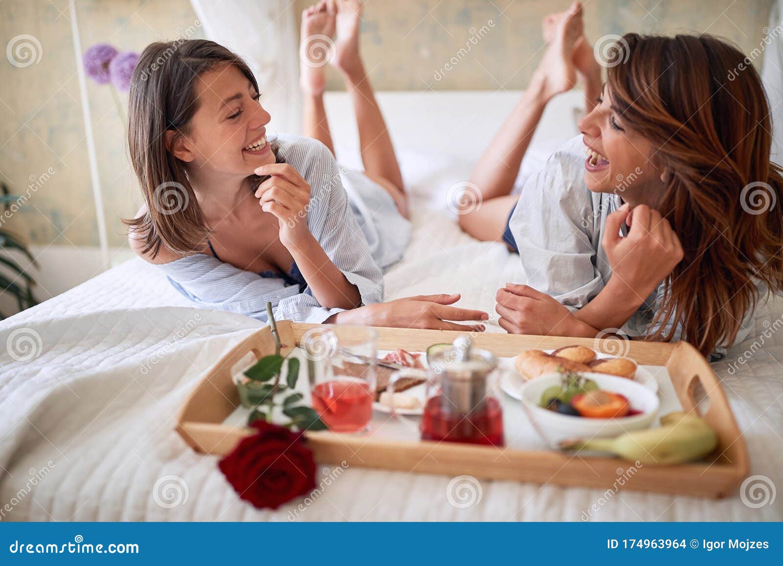 lesbians sitting legs crossed breakfast bed talking smiling watching each other love lesbian couple romantic breakfast 174963964
