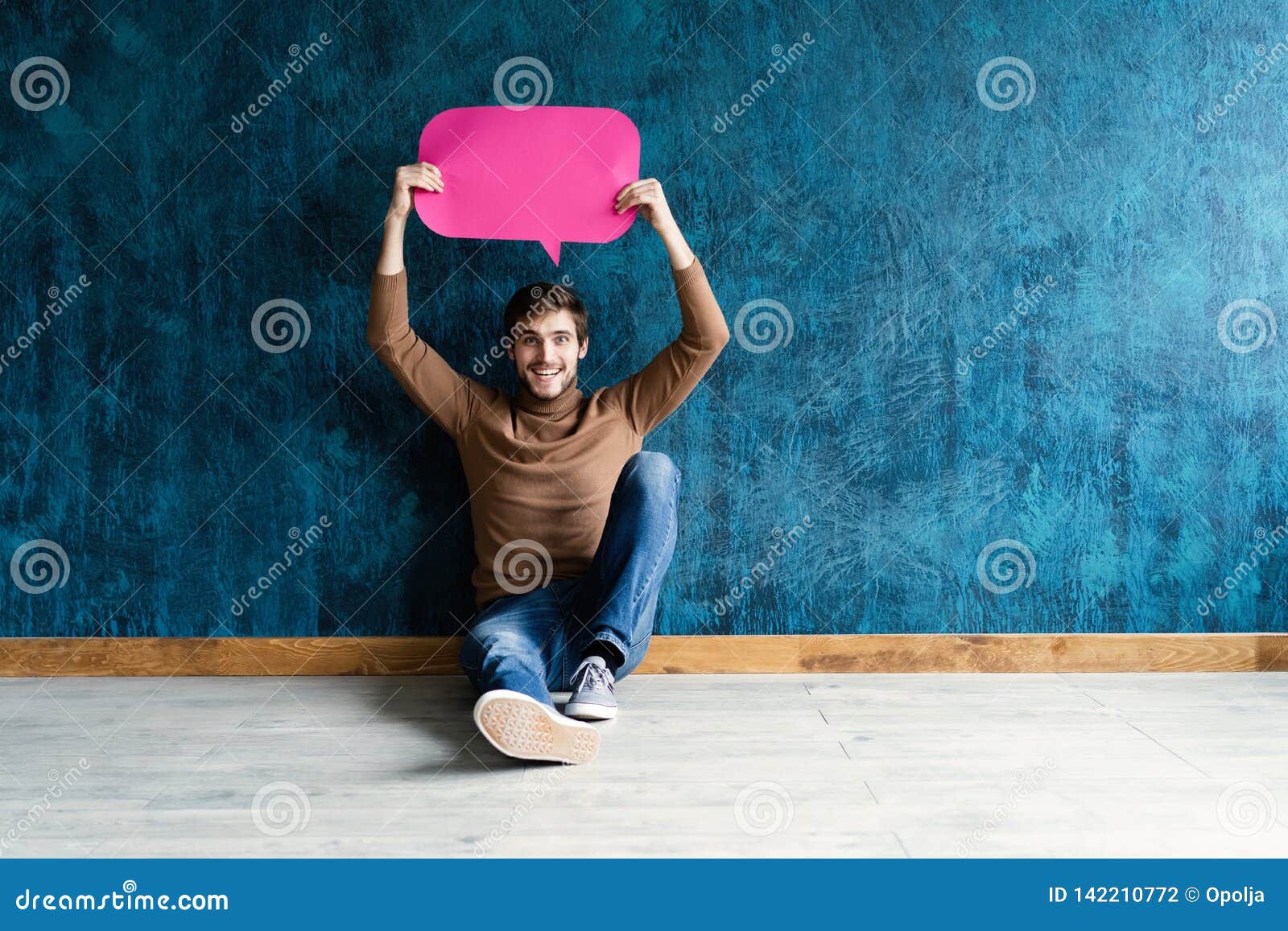 let`s start a conversation. i speak the language of success. handsome young man holding up speech bubble  on