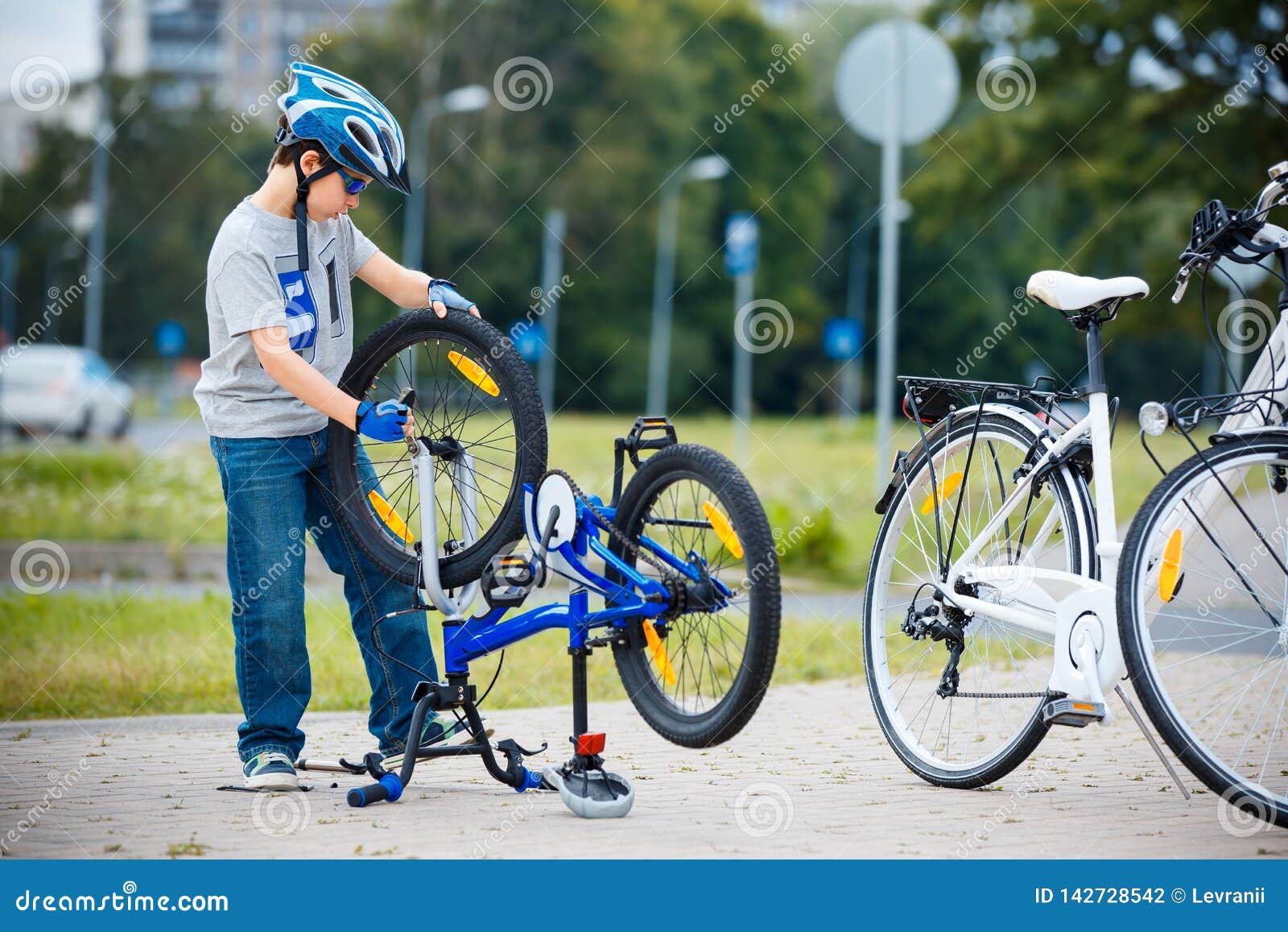 Leuk weinig jongen die zijn fiets in openlucht herstellen. Leuk weinig jongen die fiets herstellen in openlucht bij de zomer