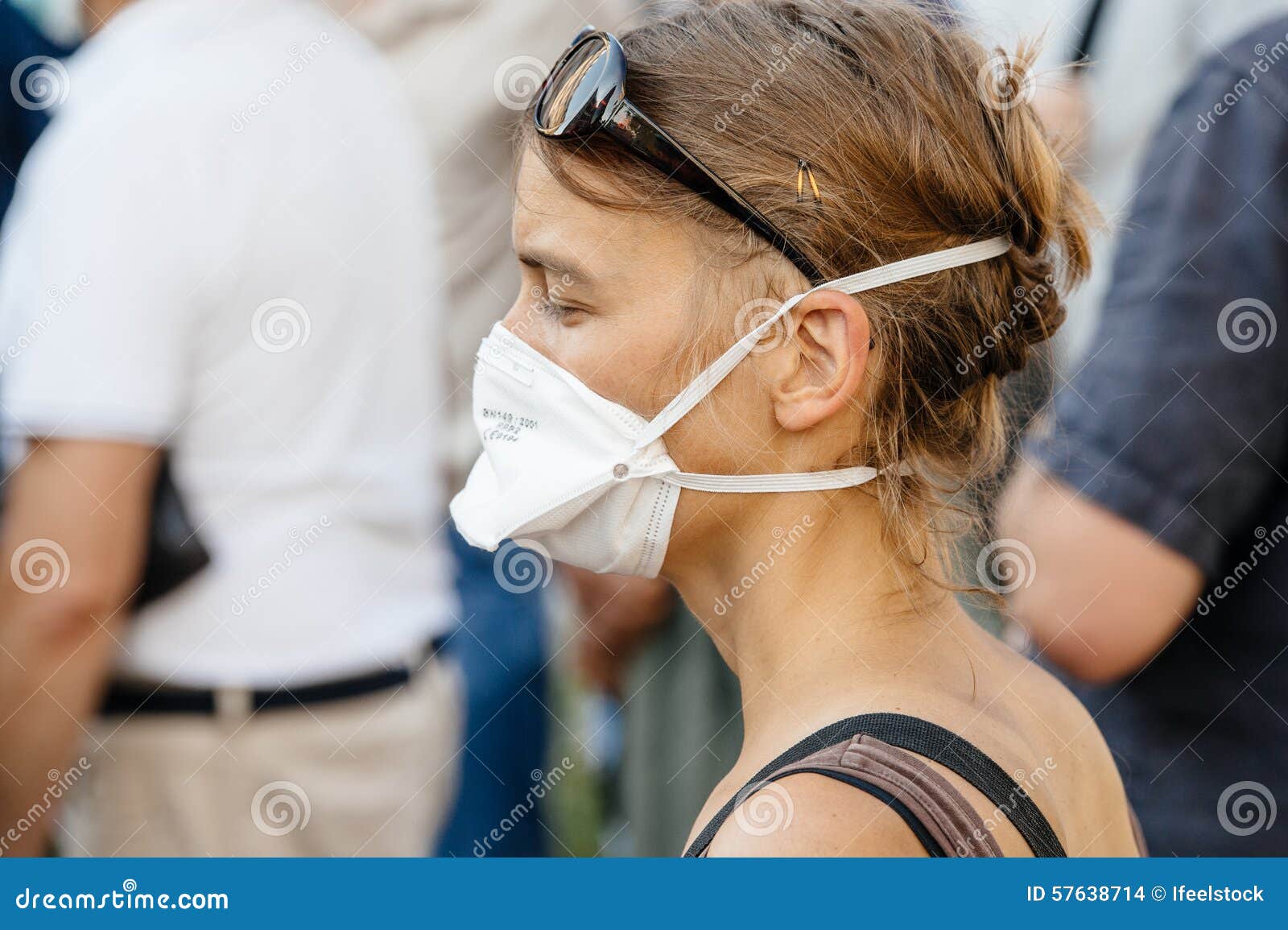 Leute, die gegen Luftverschmutzung protestieren. STRASSBURG, FRANKREICH - 6. AUGUST 2015: Tragende Beatmungsmasken der Leute, die gegen Luftverschmutzung in Straßburg, Elsass, Frankreich - tragende Maske der Frau protestieren