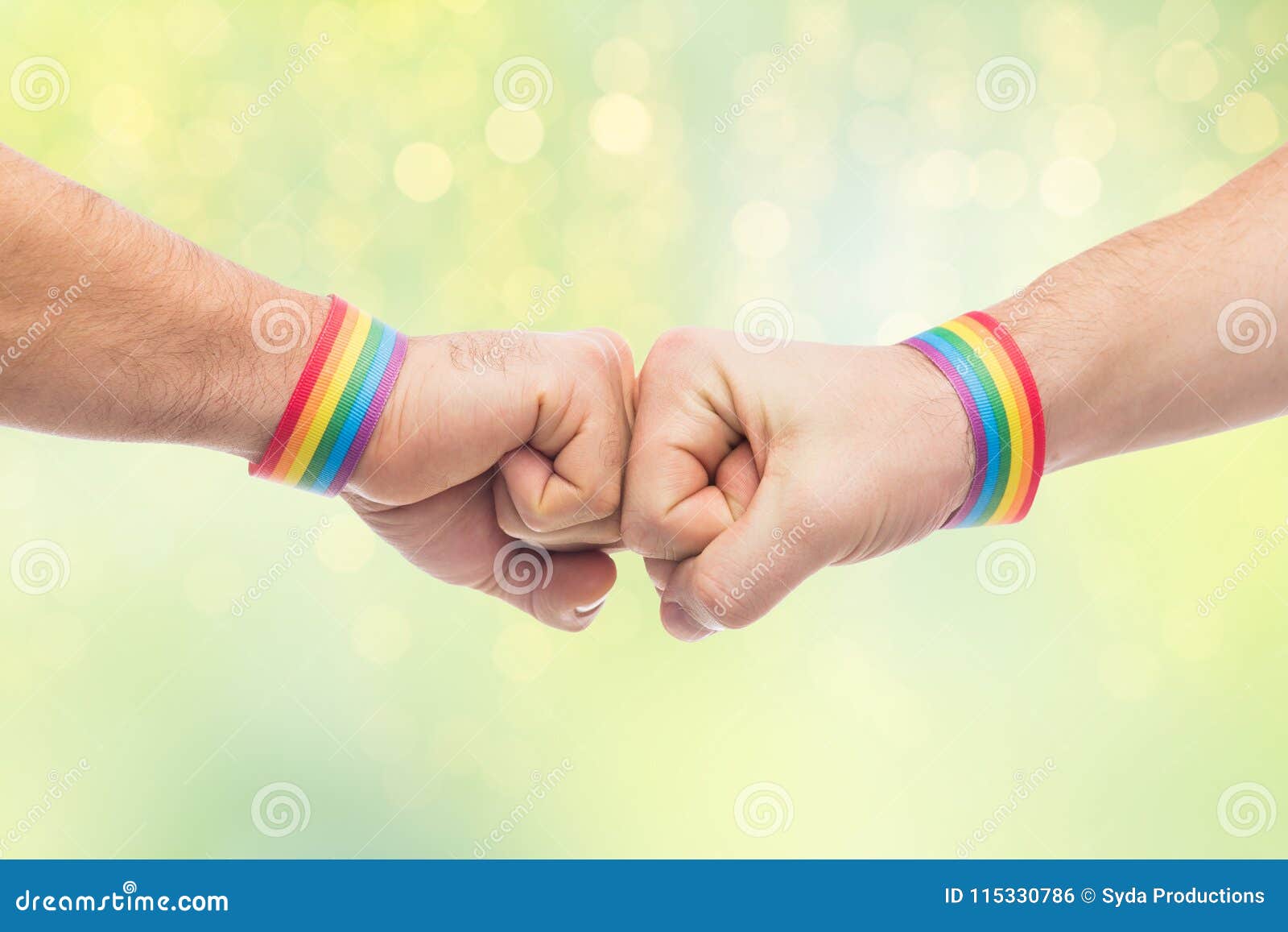 hands with gay pride wristbands make fist bump