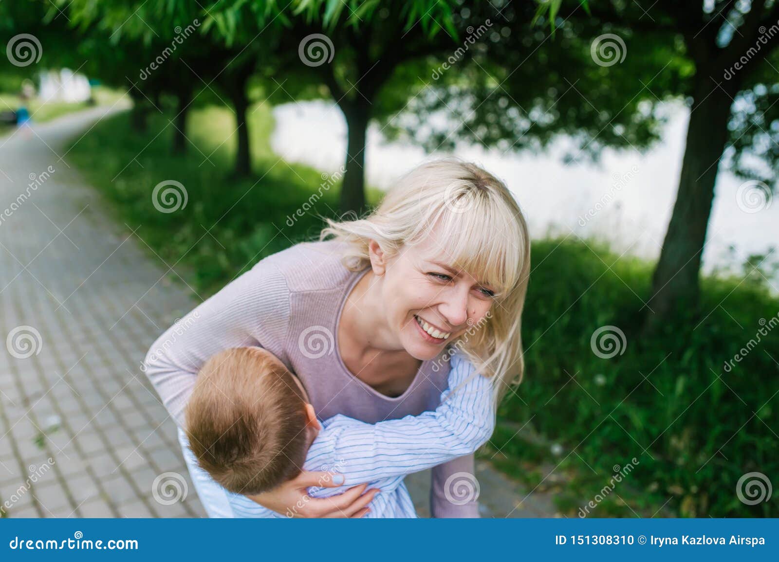 Cute cheerful child with mother play outdoors in park. Closeup photo
