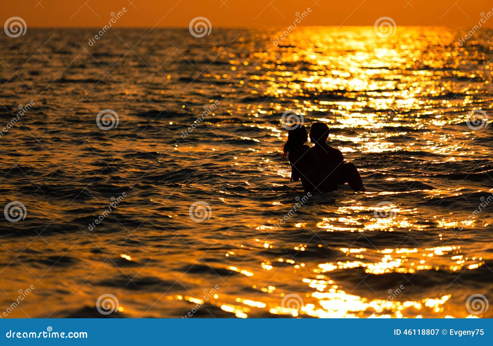 Liebevolle Paare bei Sonnenuntergang im Meer. Das liebevolle Paar geht bei Sonnenuntergang im Meer