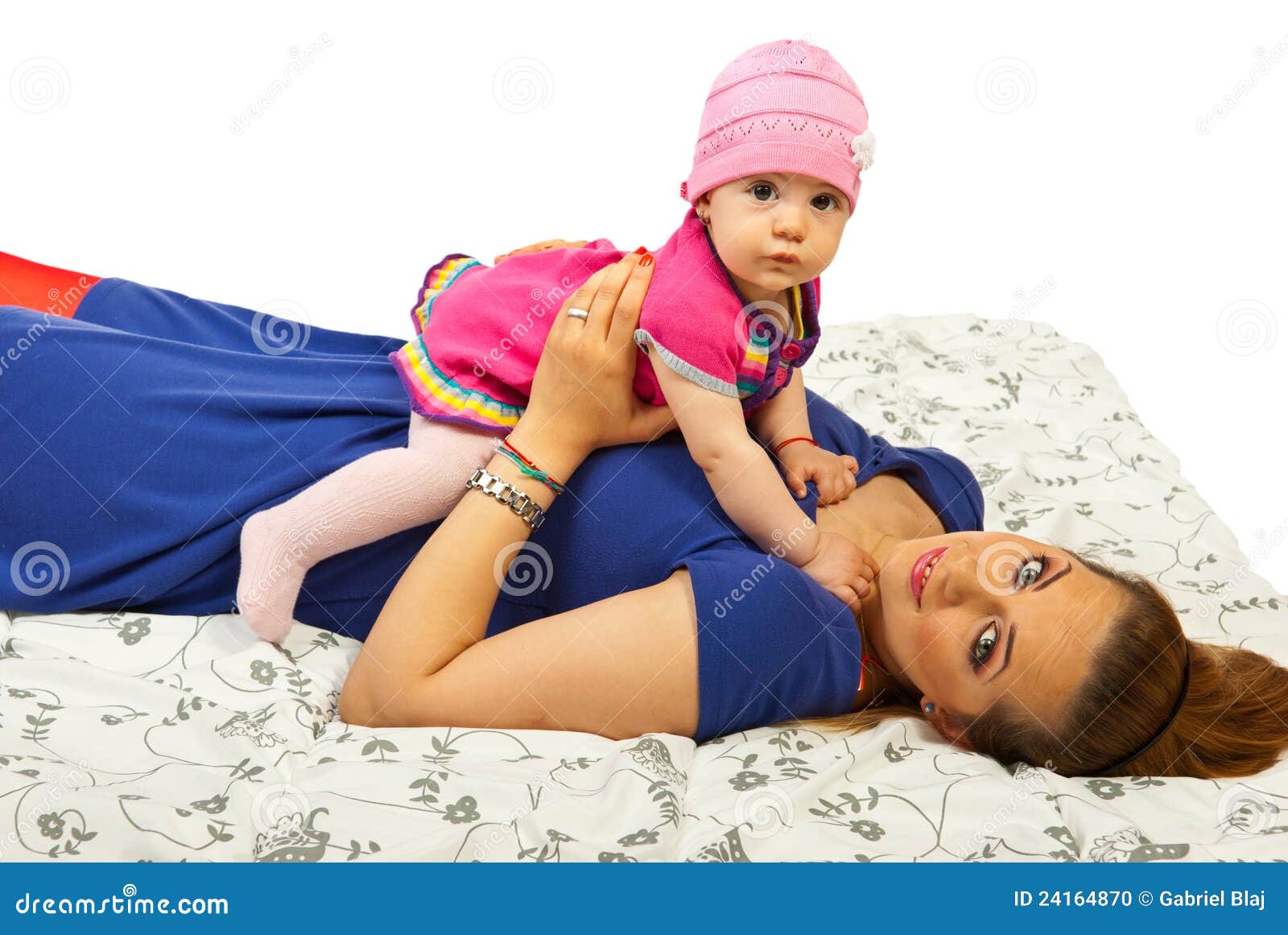 Liegenmutter mit ihrem Schätzchen. Lächelnde Mutter, die ein Rückseite und Anhalten ihres Babys gegen weißen Hintergrund liegt