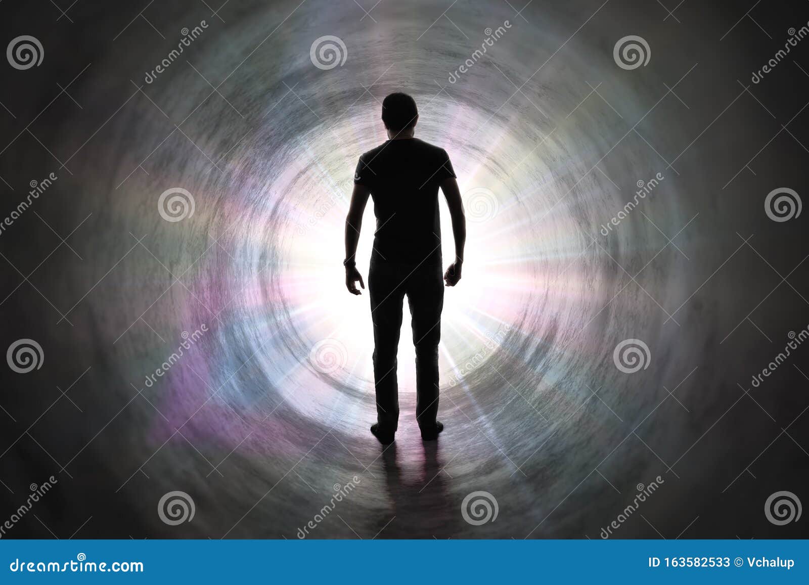 life after death concept. silhouette of man`s soul is walking to bright light - rays of god inside tunnel.