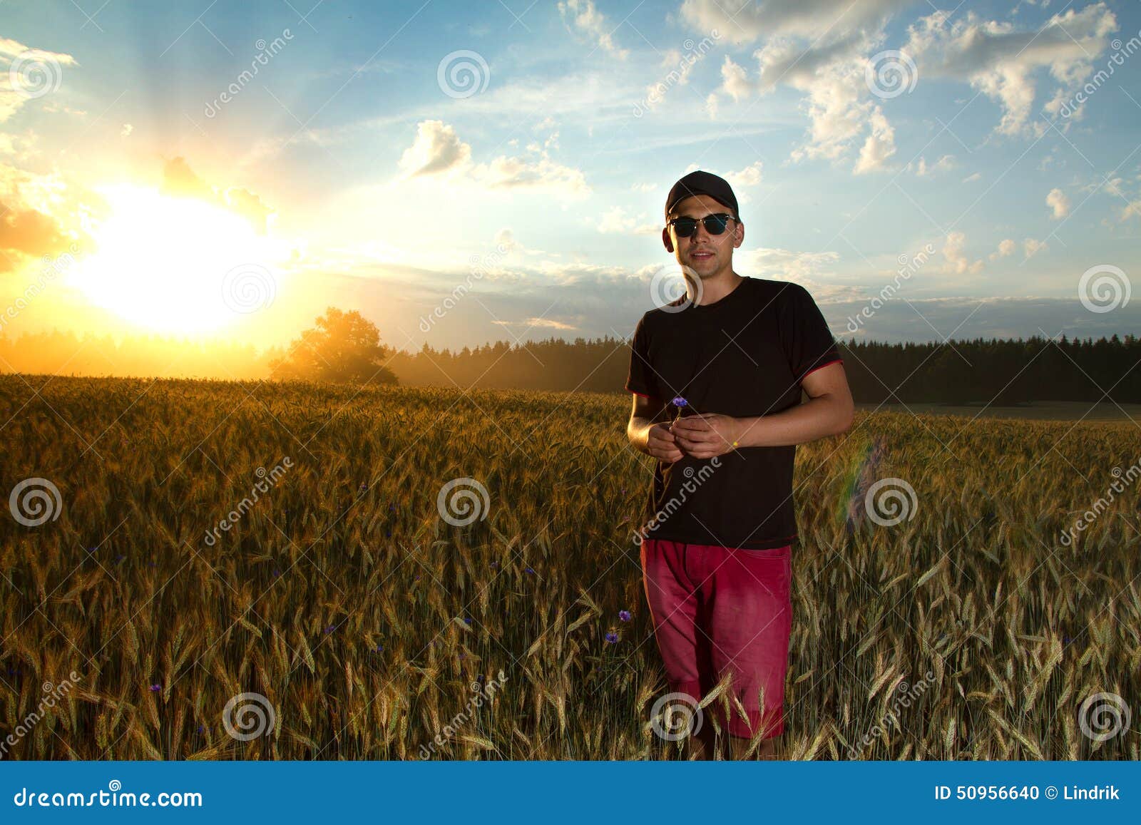 Lifestyle un hombre en un campo en la puesta del sol que disfruta de vida, del buen tiempo, del aire fresco y del silencio