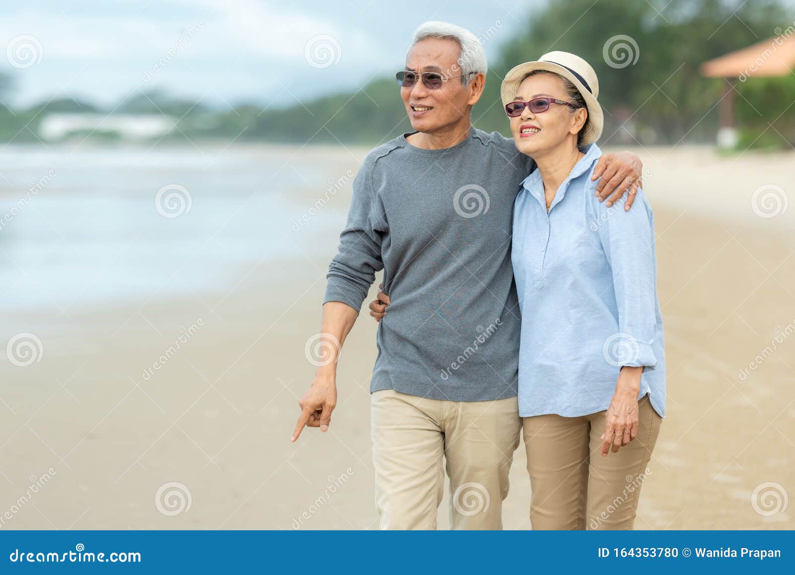 lifestyle asian senior couple happy walking and relax on the beach.  tourism elderly family travel leisure and activity after reti