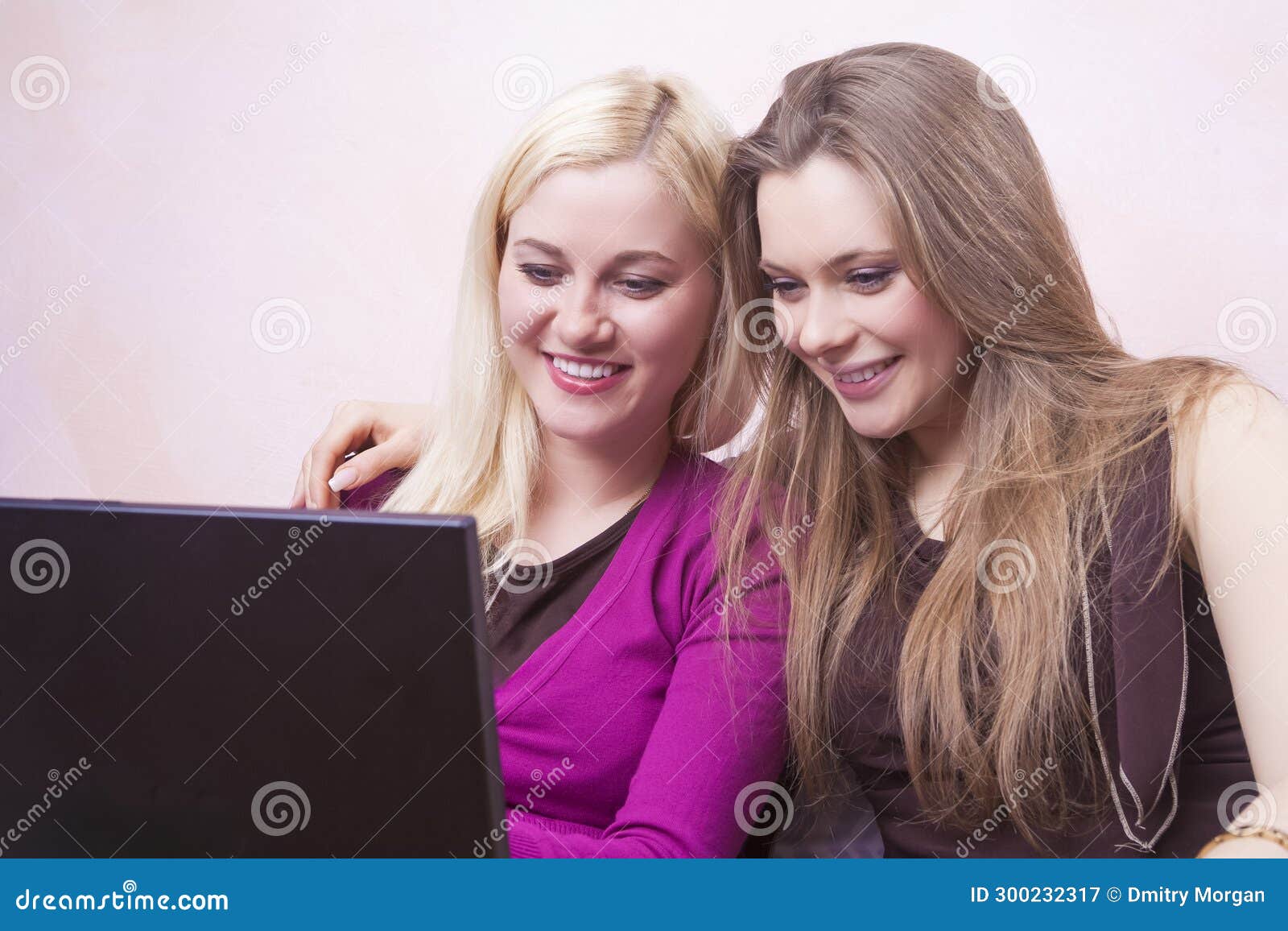 lifestyle ideas. two winsome happy expressive positive caucaisan girlfriends having fun while working with laptop