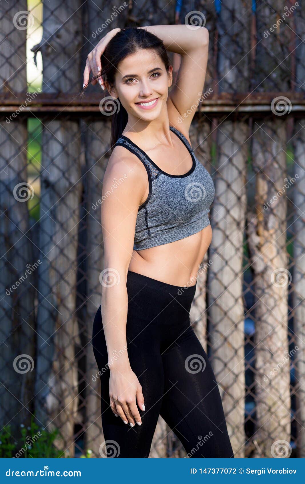 Lifestyle Portrait of Fitness Pretty Young Woman Wearing Grey