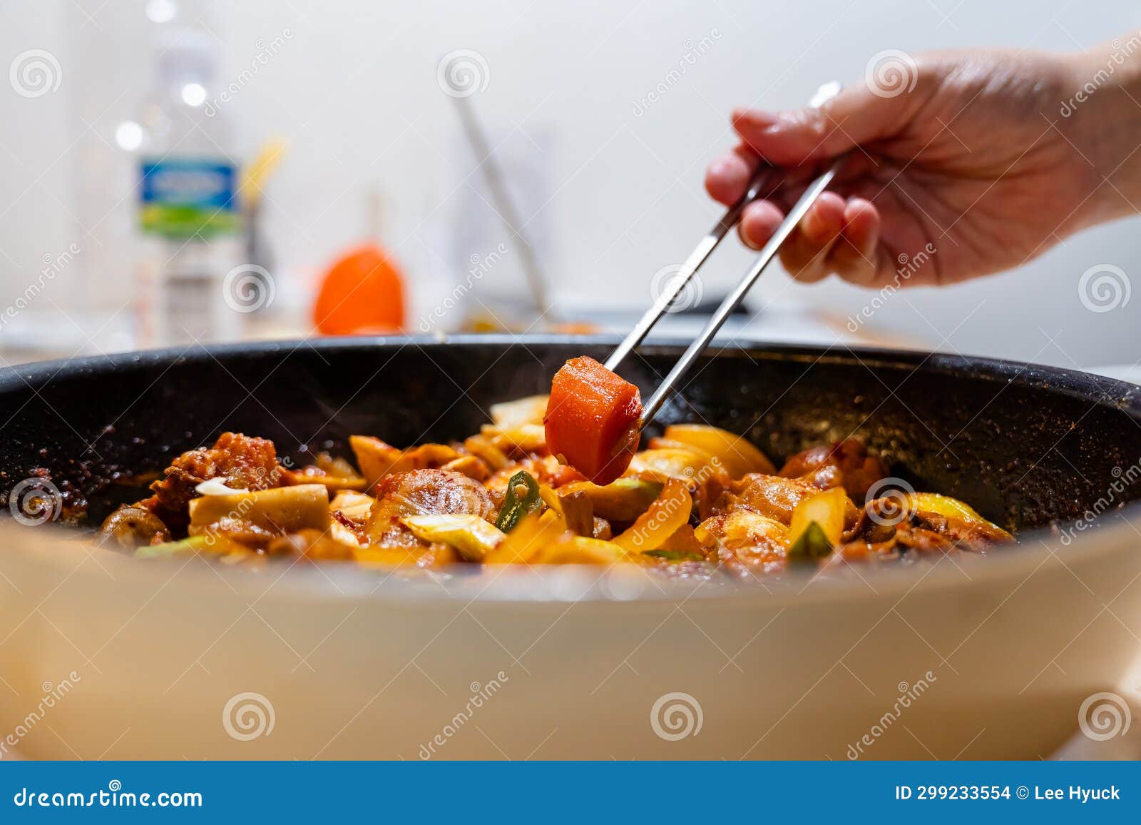 lifting carrots from stir-fried chicken with chopsticks